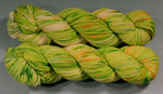 Green and yellow skeins of yarn on a gray background