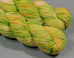 Green and yellow skein of yarn on a gray background